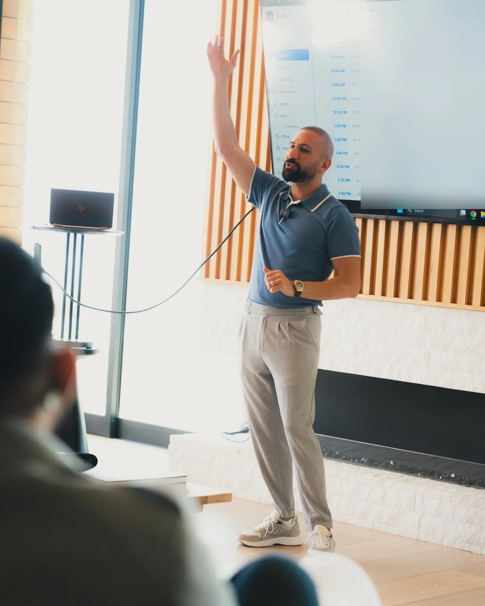 Sal Shakir presenting to business owners with one arm raised
